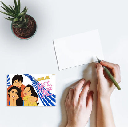 A person writing a postcard featuring artwork of Shah Rukh Khan, Madhuri Dixit and Karisma Kapoor from the Bollywood film Dil to Pagal Hai on a postcard.
