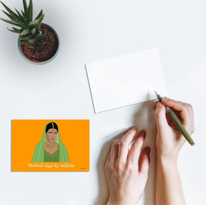 Person writing on a postcard featuring artwork of Kajol's mehndi look from the film Dilwale Dulhania Le Jayenge (1995)